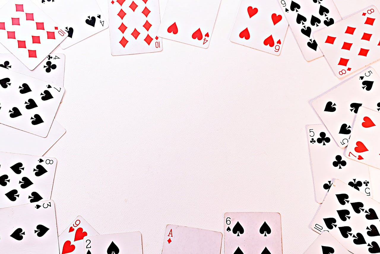 A circle of dispersed playing cards on a white surface, perfect for games and gambling themes.